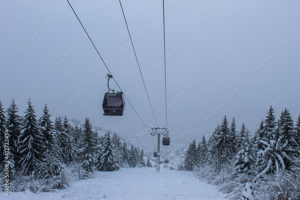 Cable car photographed from Trebevic in winter while it is snowing. Snow in winter on the mountain Trebevic. Sarajevo cable car in nature. Winter and snow.