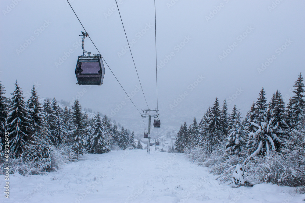 Cable car photographed from Trebevic in winter while it is snowing. Snow in winter on the mountain Trebevic. Sarajevo cable car in nature. Winter and snow. Cable car photographed from Trebevic in winter while it is snowing. Snow in winter on the mountain Trebevic. Sarajevo cable car in nature. Winter and snow.