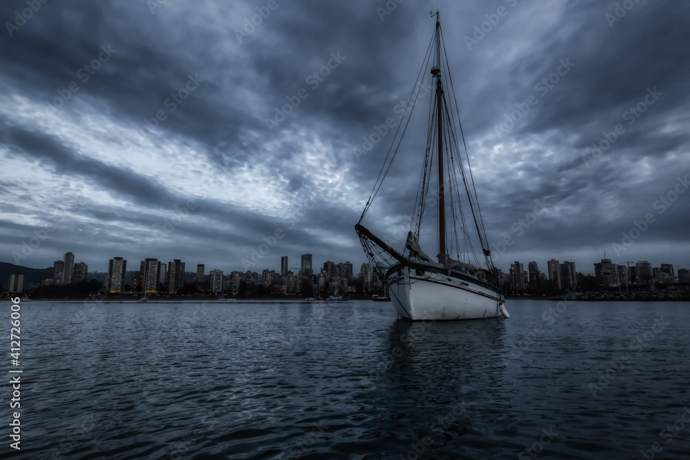 Dark Moody View of the Sailboat in water with Downtown City in background. Taken in Kitsilano, Vancouver, British Columbia, Canada. Artistic Render Dark Moody View of the Sailboat in water with Downtown City in background. Taken in Kitsilano, Vancouver, British Columbia, Canada. Artistic Render