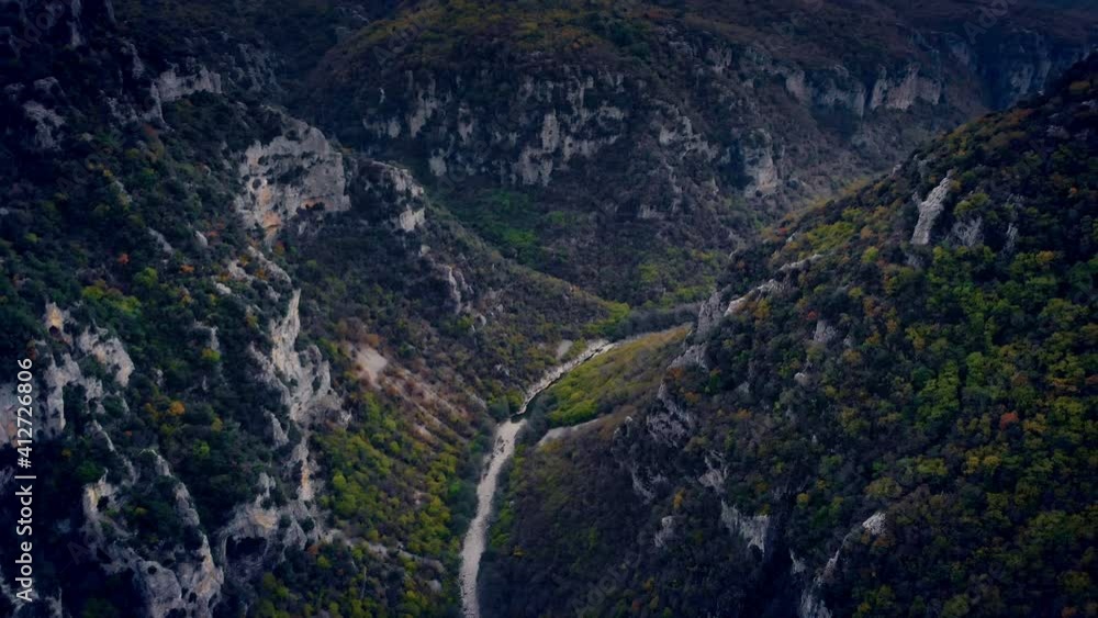 Vikos canyon beautiful nature with green steep slopes, aerial forward motion view following the riverbed Vikos canyon beautiful nature with green steep slopes, aerial forward motion view following the riverbed