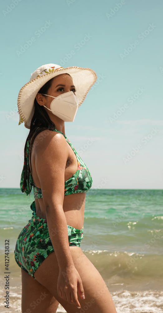jeven girl on the beach with mask, new normal, vacation on a tropical beach, preventing a virus with a facemask