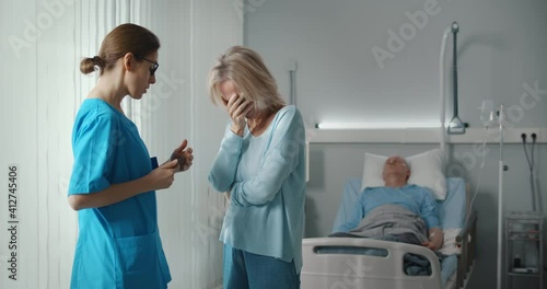 Doctor telling bad news to aged male patient wife in hospital