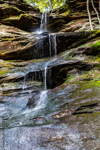 A three stage waterfall and then a waterslide over layered sandstone covered with lichen, Sipsey Wilderness, Alabama