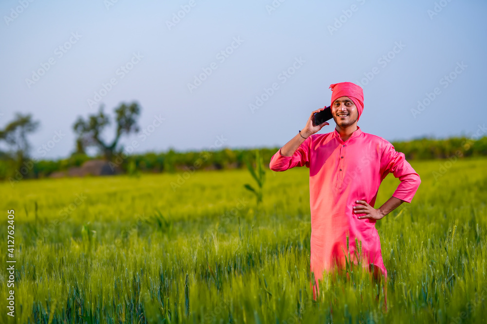 Young indian farmer talking on smartphone at wheat field Young indian farmer talking on smartphone at wheat field