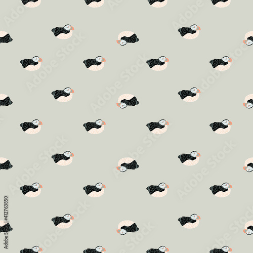 Abstract little seamless pattern with hand drawn puffin silhouettes. Grey background. Doodle design.