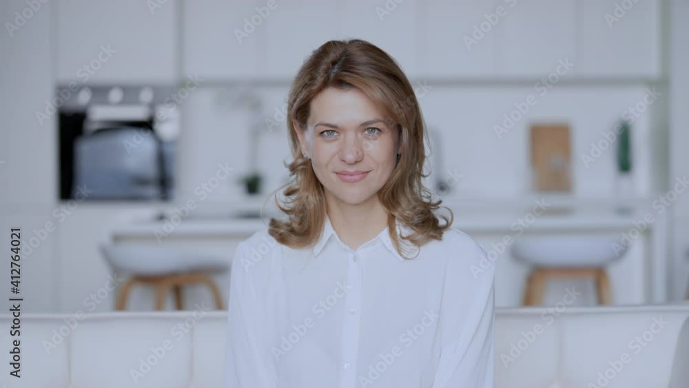portrait adult caucasian woman at home happy friendly smiling slow motion on the background white interior in flat portrait adult caucasian woman at home happy friendly smiling slow motion on the background white interior in flat