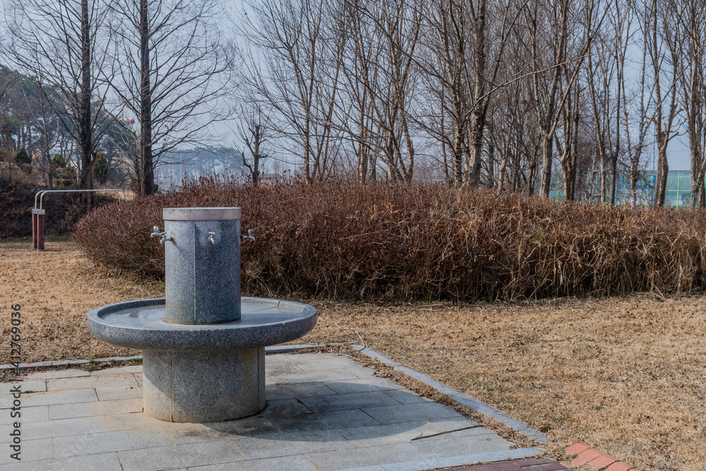 Public drinking fountain with many faucets in park