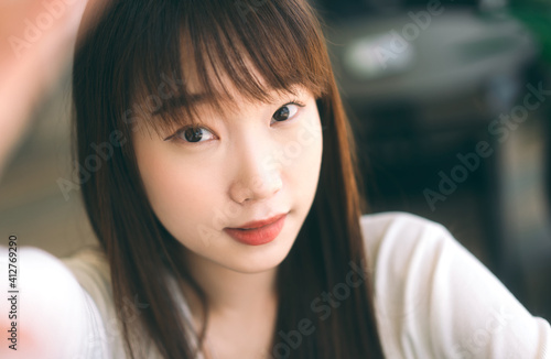 Portrait of young cute asian teenager student woman take a selfie photo by mobile phone © dodotone