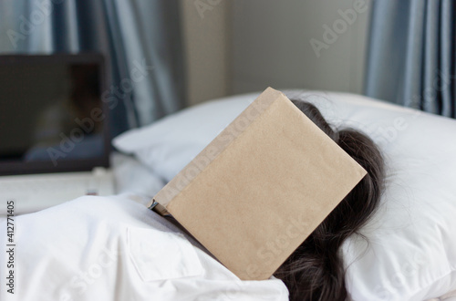 Little kid girl sleeping with book on her face