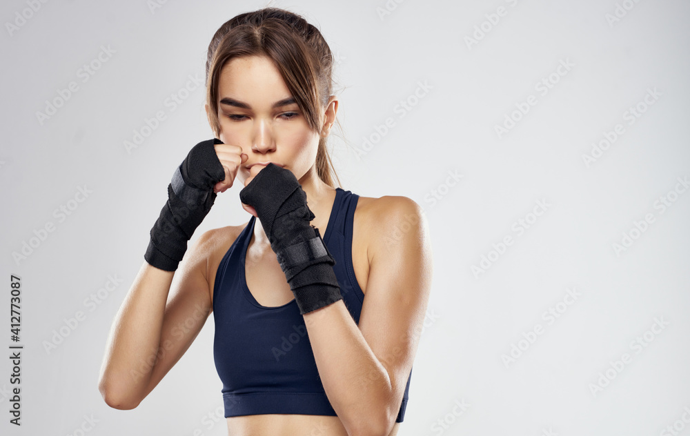 Woman boxer in gloves on gray background cropped view of brunette model Woman boxer in gloves on gray background cropped view of brunette model
