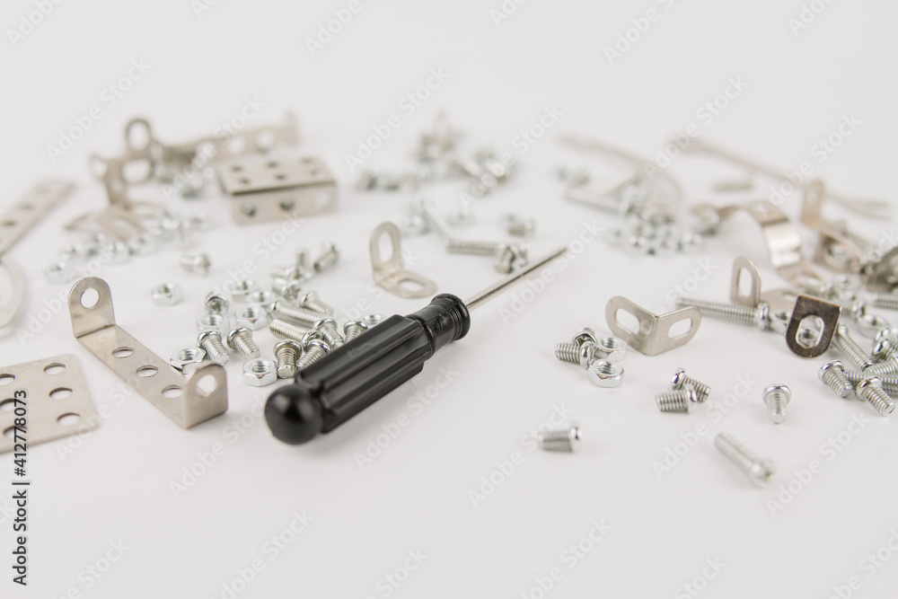 children's iron constructor with nuts and screws and a screwdriver on a white background children's iron constructor with nuts and screws and a screwdriver on a white background