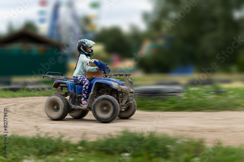 Fototapeta Naklejka Na Ścianę i Meble -  a child rides an ATV on the track
