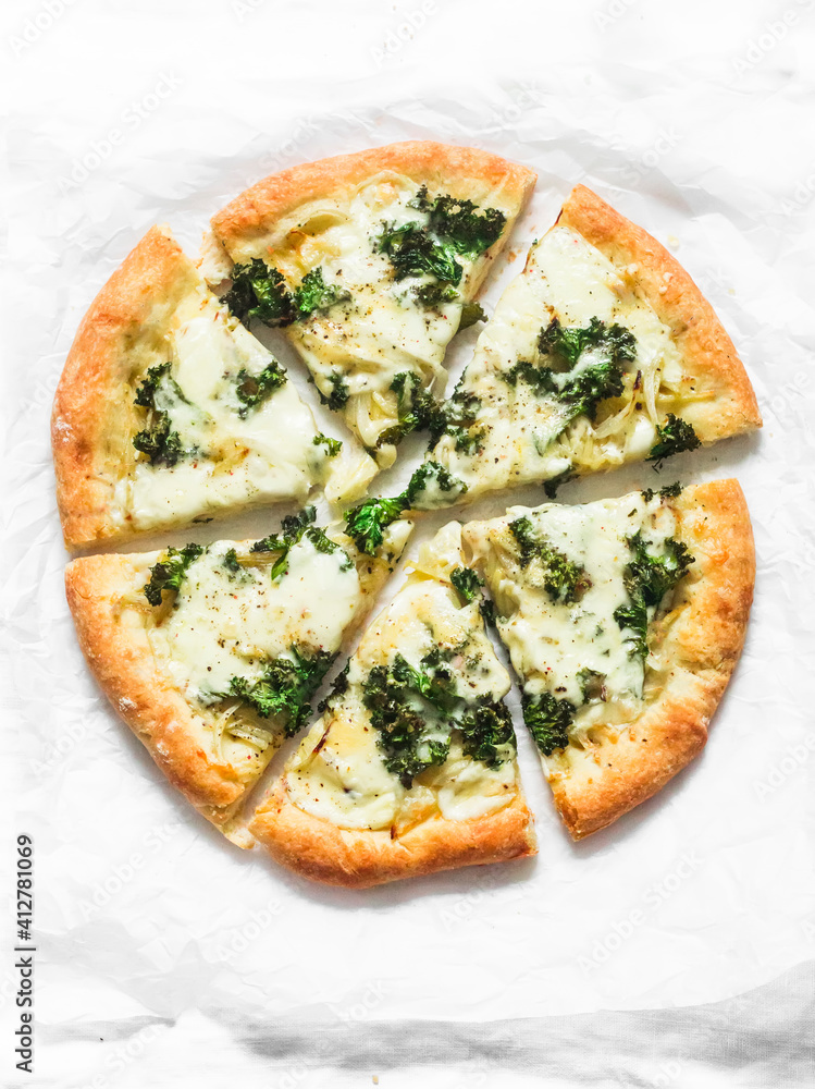 Slice of vegetarian potato, kale cabbage, mozzarella cheese pizza on a light background, top view Slice of vegetarian potato, kale cabbage, mozzarella cheese pizza on a light background, top view