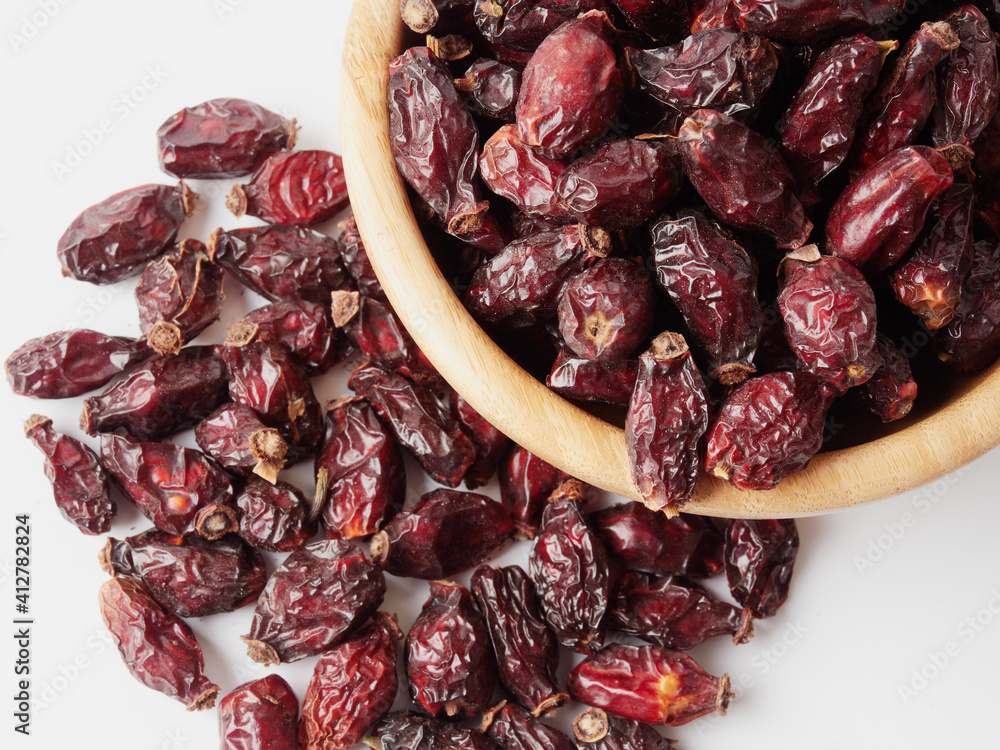 Dried berries of Dog Rose or Rosa canina. Dry fruits of sweet-brier or rose hips on wooden background. Healthy and herbal concept. Selective focus. Natural vitamin, nutritional supplement for health Dried berries of Dog Rose or Rosa canina. Dry fruits of sweet-brier or rose hips on wooden background. Healthy and herbal concept. Selective focus. Natural vitamin, nutritional supplement for health