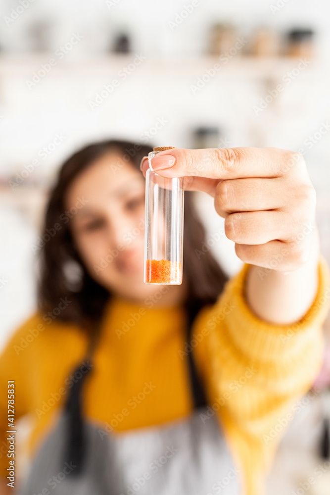 Beautiful brunette woman in yellow sweater and gray apron coloring easter eggs in the kitchen Beautiful brunette woman in yellow sweater and gray apron coloring easter eggs in the kitchen