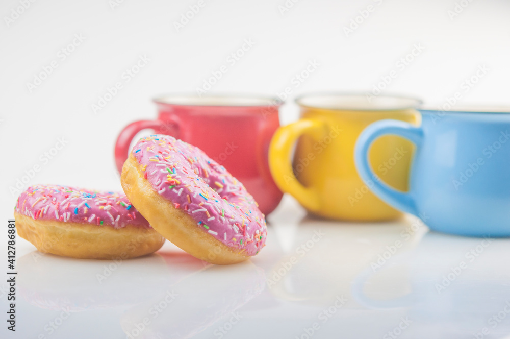 Tasty donut with colorful cups of coffee on white background Tasty donut with colorful cups of coffee on white background