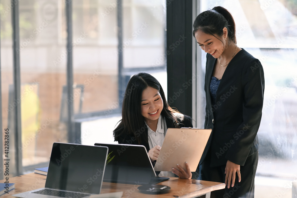 Two successful businesswoman examining and analyzing the growth rate of investment at modern office. Two successful businesswoman examining and analyzing the growth rate of investment at modern office.