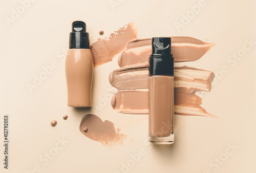 Fotografía Bottles of makeup foundation and samples on color background
