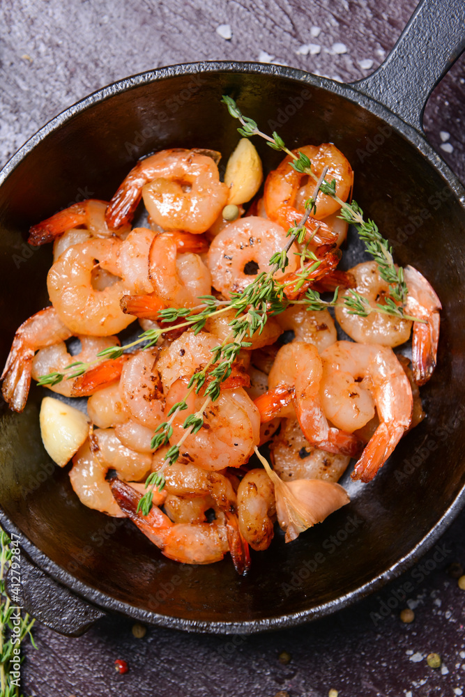 Frying pan with tasty shrimps on dark background Frying pan with tasty shrimps on dark background