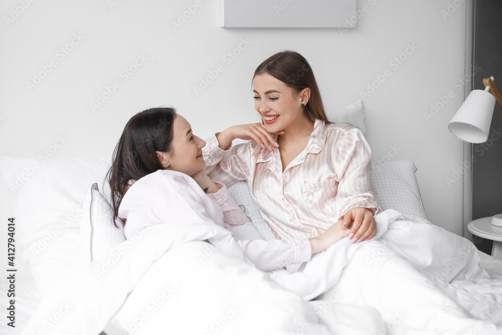 Obraz premium Young lesbian couple resting in bed