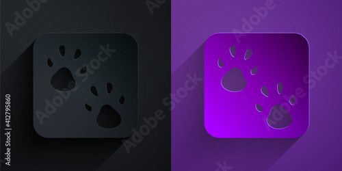 Paper cut Paw print icon isolated on black on purple background. Dog or cat paw print. Animal track. Paper art style. Vector.