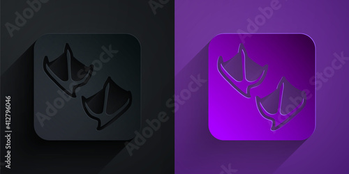 Paper cut Seagull paw footprint icon isolated on black on purple background. Paper art style. Vector.