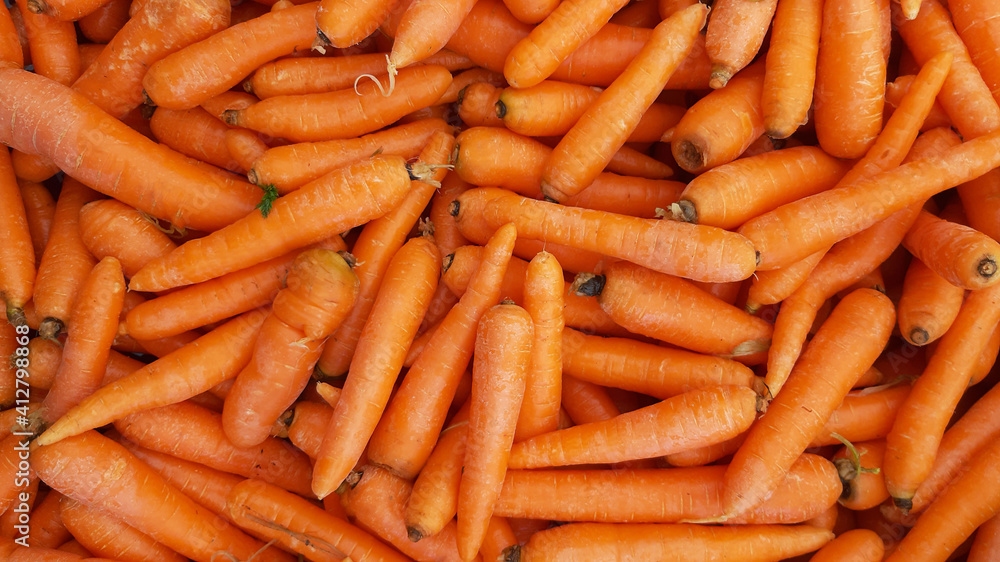 Organic carrots background. Stack of fresh carrots at the market and popular cooking vegetable or fruit Organic carrots background. Stack of fresh carrots at the market and popular cooking vegetable or fruit