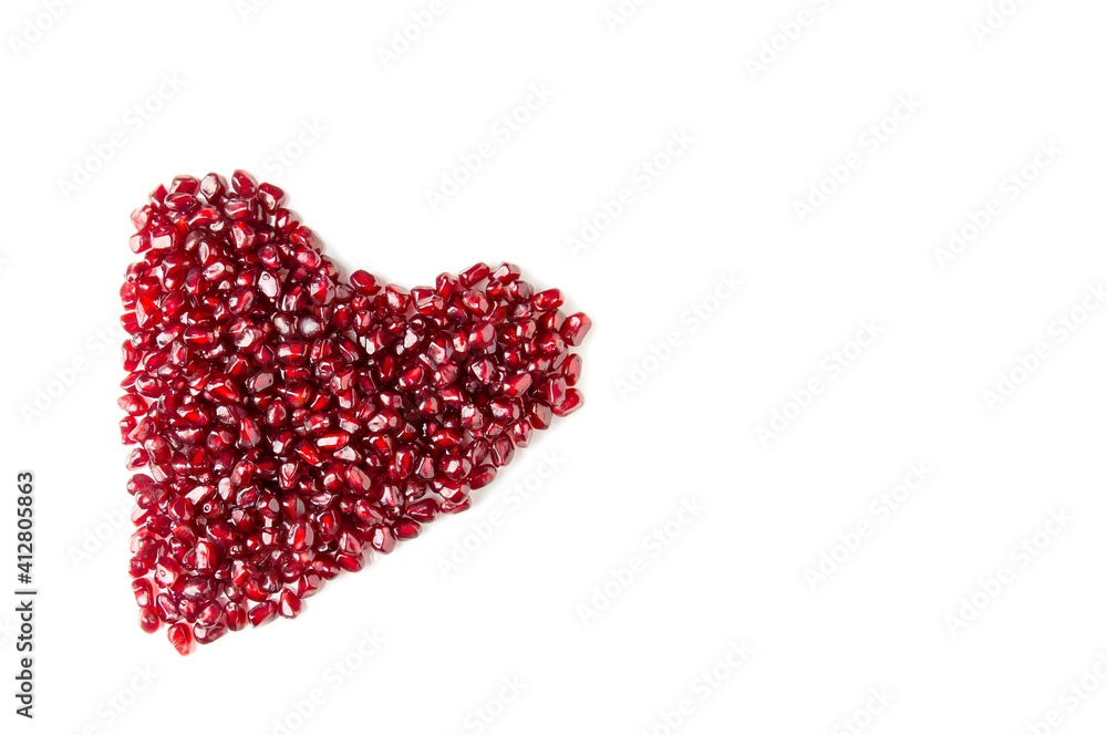 Heart from pomegranate seeds on a white background.