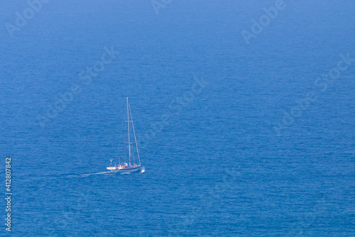 White sail boat on blue water of sea. Minimal composition with copyspace