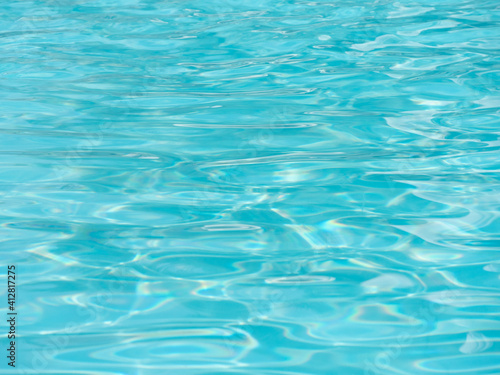 Shiny bright blue water surface in the swimming pool with waves. © ersoy