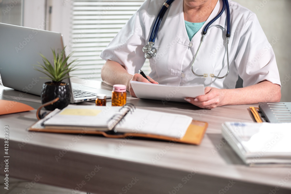Female doctor reading medical report Female doctor reading medical report