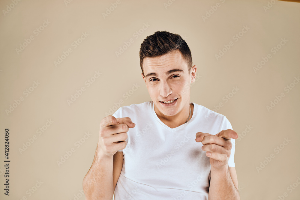 Cute emotional man white t-shirt gesture with hands cropped view beige studio background Cute emotional man white t-shirt gesture with hands cropped view beige studio background