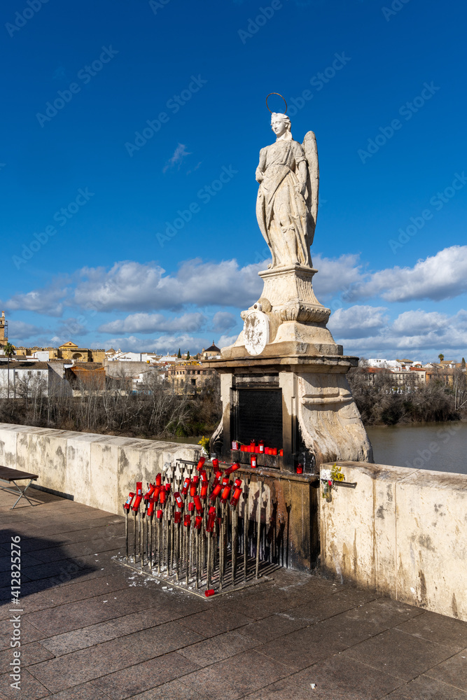 Fototapeta premium statue with candles and offerings on the Roman Bridge in Cordoba
