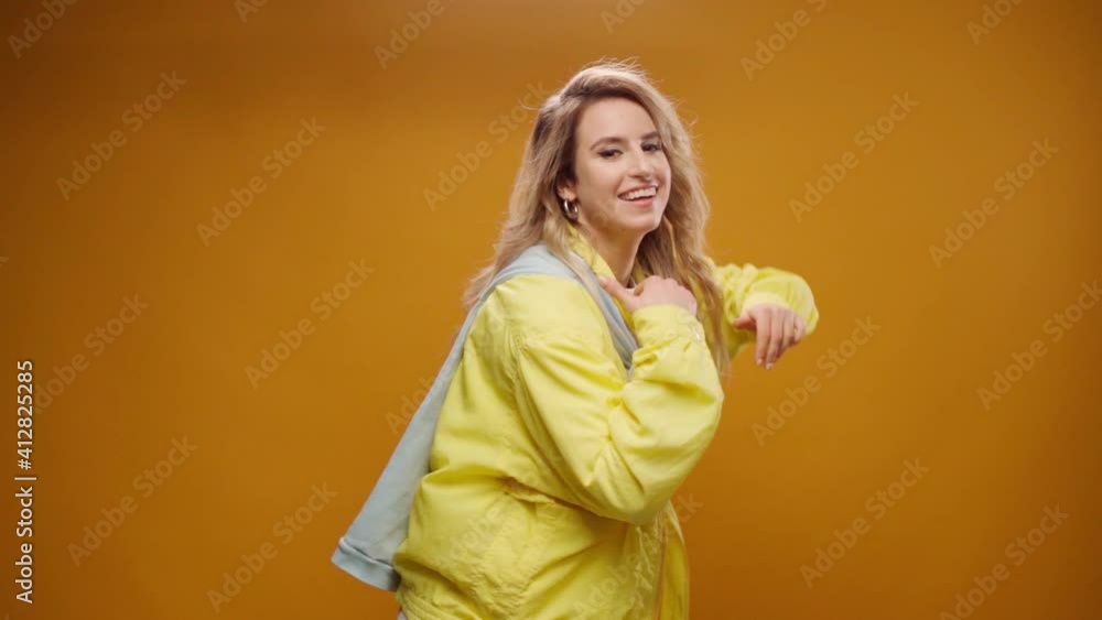 Woman professional dancer dancing in studio against yellow background Woman professional dancer dancing in studio against yellow background