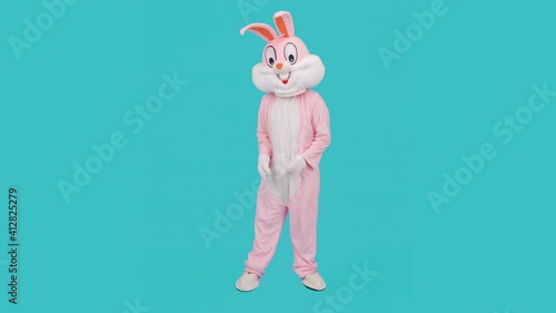 Positive funny crazy man dancer is dancing, having fun, rejoices, isolated on blue. Easter bunny or rabbit or hare celebrates Happy easter