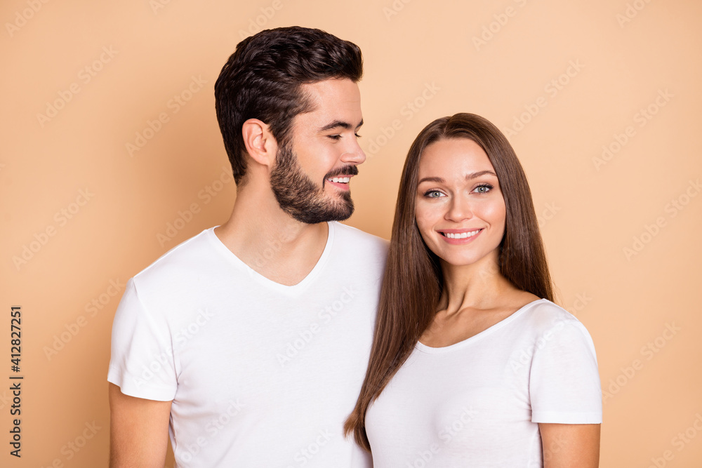 Fototapeta premium Photo of cute adorable married couple dressed white t-shirts smiling embracing isolated beige color background