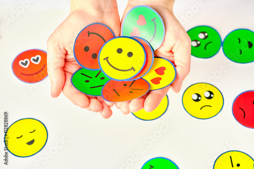 Holding with your hands all possible emotions, because they all have to work and are essential in people and in all moments of life, emotional education, emoticons, psychology.