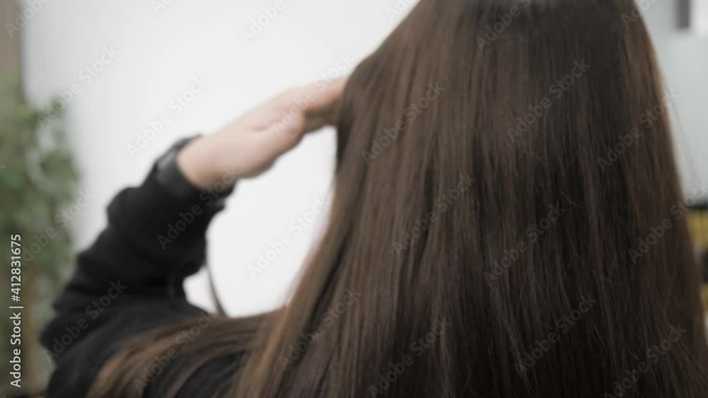 Demonstration of the brunette's hair before straightening it. Brittle tangled brunette hair. High quality 4k footage. The brunette shows off her hair, pointing out its carelessness. Demonstration of the brunette's hair before straightening it. Brittle tangled brunette hair. High quality 4k footage. The brunette shows off her hair, pointing out its carelessness.