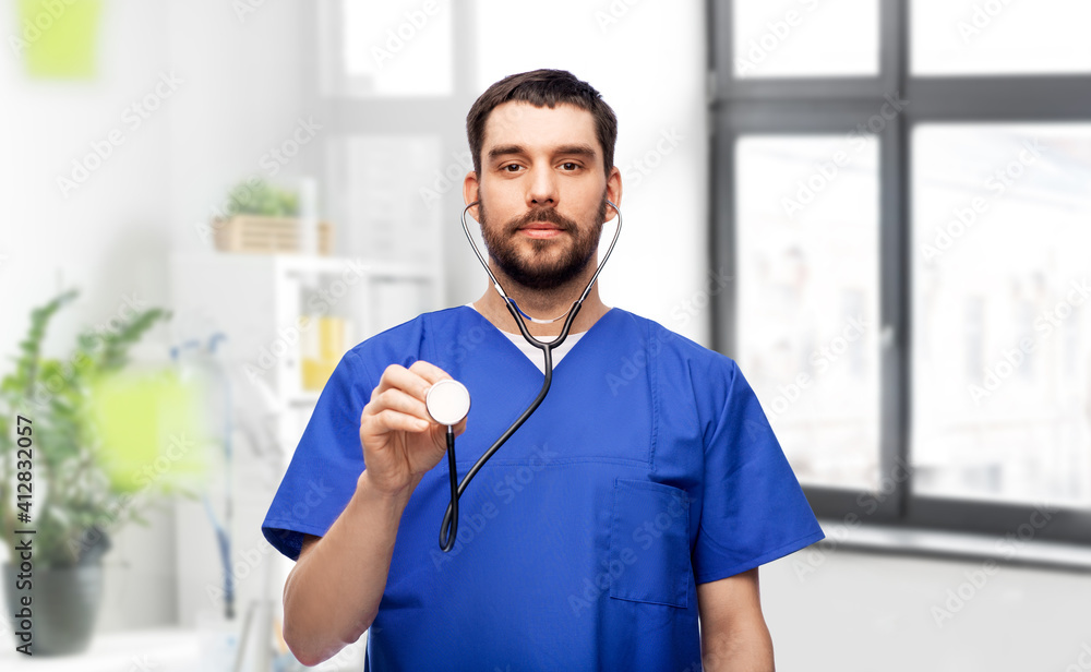Fototapeta premium healthcare, profession and medicine concept - doctor or male nurse in blue uniform with stethoscope over medical office at hospital background