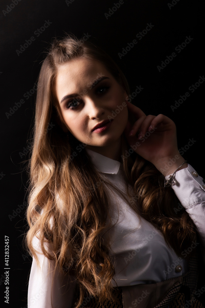 Portrait on a dark background of a young, beautiful woman with ore hair