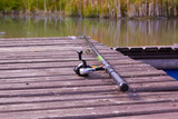 fishing tackle lying on a wooden bridge by the pond