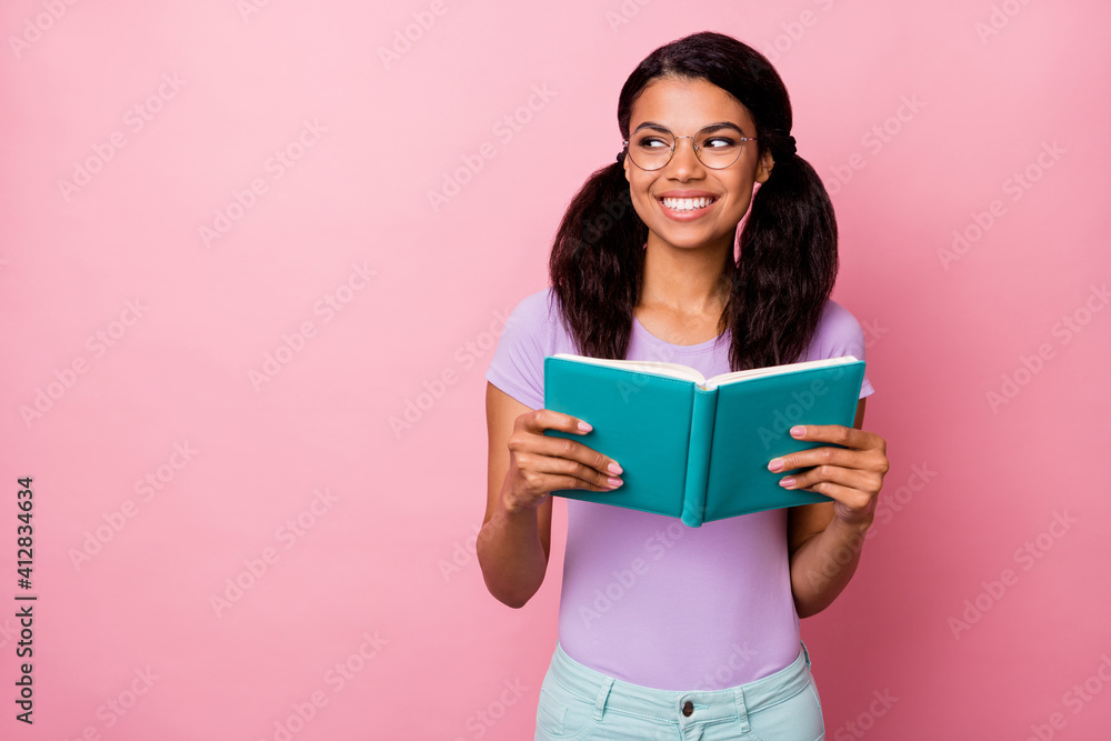 Photo of charming positive dark skin woman look empty space hold book diary isolated on pastel pink color background Photo of charming positive dark skin woman look empty space hold book diary isolated on pastel pink color background