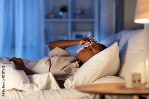 Fotografía people, bedtime and rest concept - sleepless african american woman lying in bed