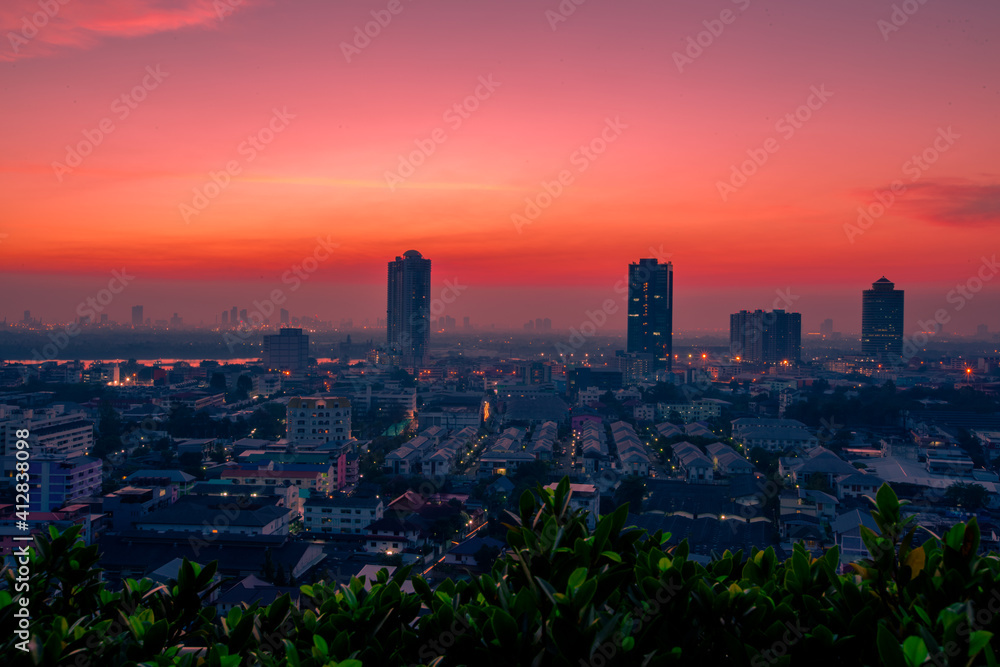 Obraz premium The high angle background of the city view with the secret light of the evening, blurring of night lights, showing the distribution of condominiums, dense homes in the capital community
