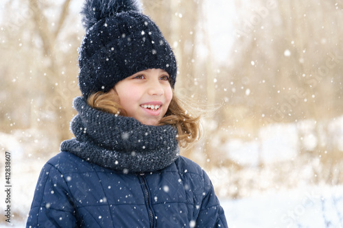 child girl playing with snow in winter outdoor and having fun on snowy winter