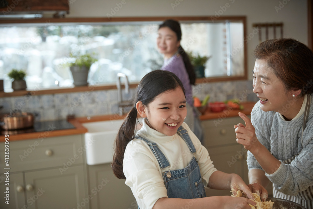 Happy adorable little child girl in apron enjoying cooking homemade pastry together with family at home. Happy adorable little child girl in apron enjoying cooking homemade pastry together with family at home.