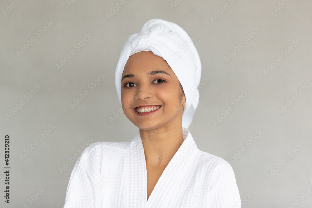 Cute teen Asian woman with white towel folding around head in white spa dress Cute teen Asian woman with white towel folding around head in white spa dress