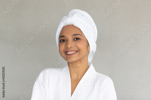 Cute teen Asian woman with white towel folding around head in white spa dress