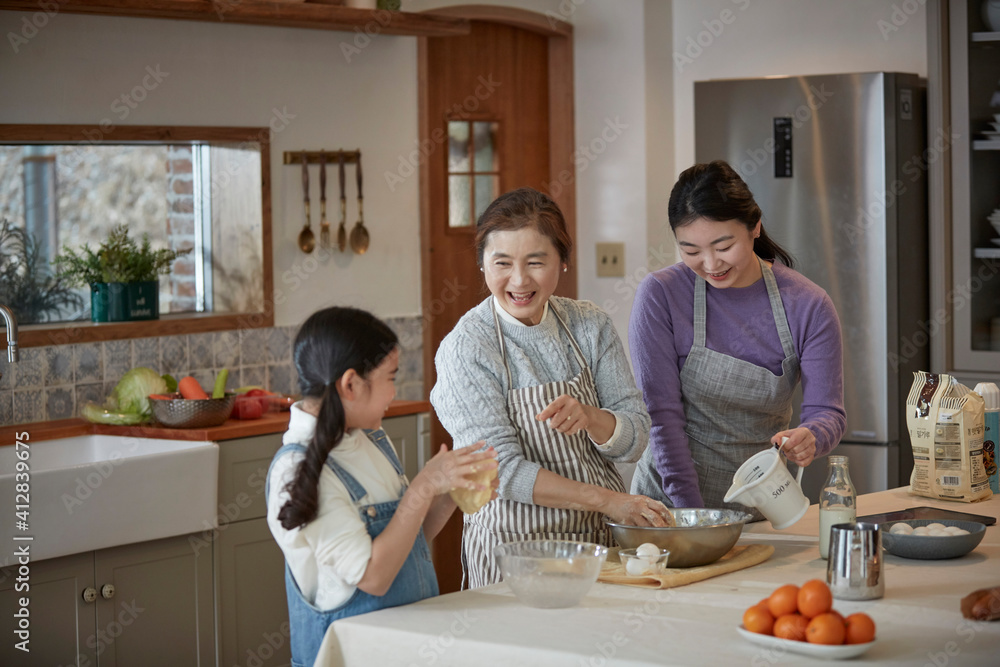 Happy adorable little child girl in apron enjoying cooking homemade pastry together with family at home. Happy adorable little child girl in apron enjoying cooking homemade pastry together with family at home.