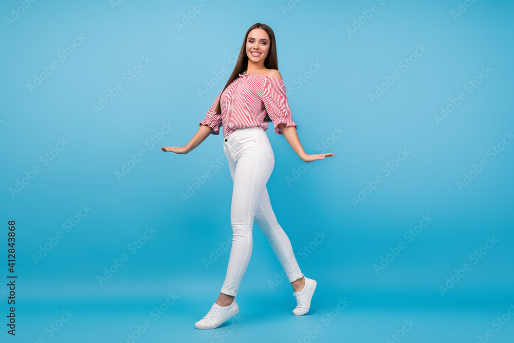 Full length body size view of pretty cheerful straight-haired girl walking having fun isolated over bright blue color background Full length body size view of pretty cheerful straight-haired girl walking having fun isolated over bright blue color background